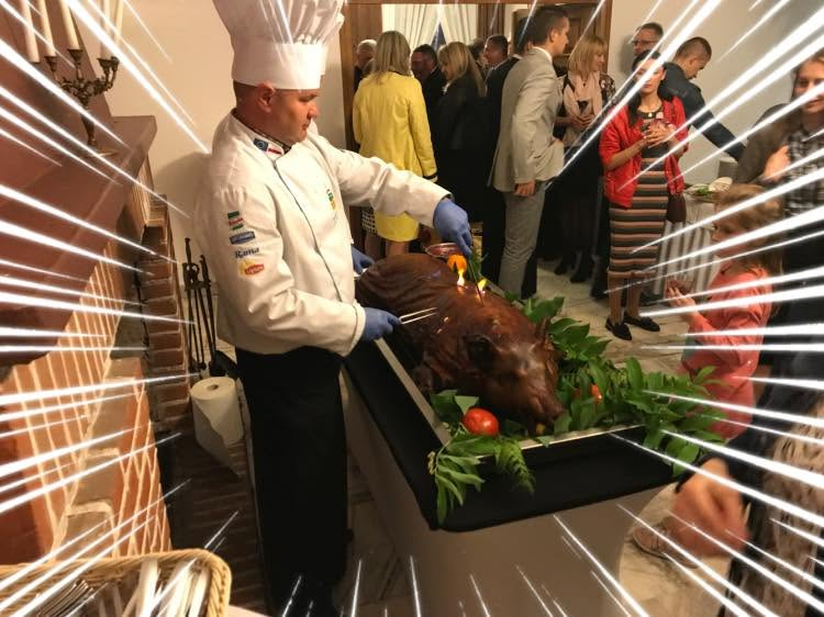 Kucharz porcjujący pieczonego dzika podczas przyjęcia